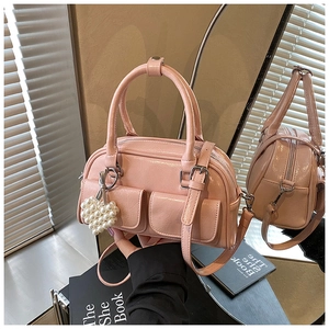 Detailansicht einer rosa Boston Bag mit Herz-Perlenanhänger und zwei Vordertaschen