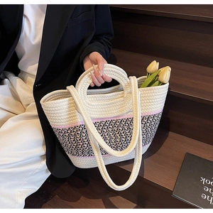 Detail of hand-woven tote bag showing thickened cotton rope texture and dual strap design