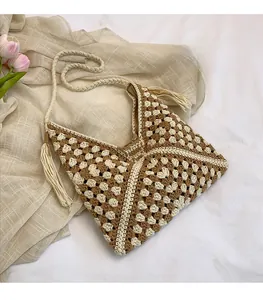 Dettaglio della borsa a tracolla in maglia geometrica con frange e tracolla intrecciata
