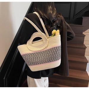 Detail view of woven tote bag with contrast pattern and ring handles for summer beach style