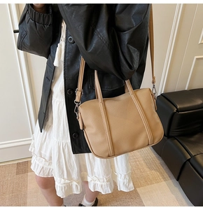 Detail of tan pebble-textured PU leather handbag with dual handles and adjustable strap