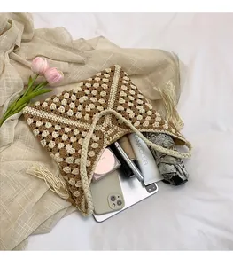 Dettaglio degli ampi interni di una borsa tote intrecciata con oggetti di uso comune