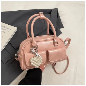 Detail der rosa Boston-Tasche mit Fronttaschen, Perlen-Herz-Anhänger und Schleife