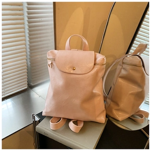 Detail of light pink glossy backpack with pleated texture and silver D-ring