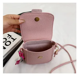 Détail du sac bandoulière rose à motif litchi montrant l'intérieur et le fermoir magnétique