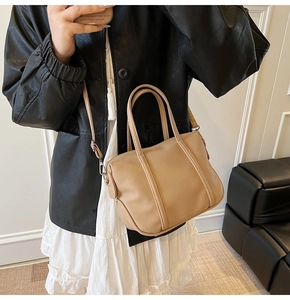 Detailed mirror selfie of a brown lychee pattern tote bag with crossbody strap