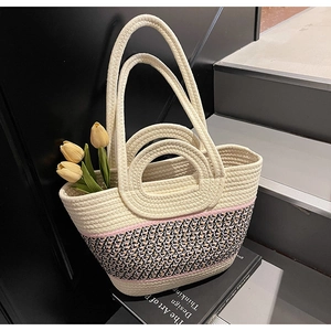 Detail of multi-color woven tote bag featuring dual handles and delicate geometric patterns