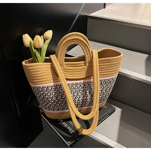 Detail of woven beach tote featuring geometric patterns and dual handles for versatile use