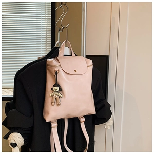 Detailed view of pink PU leather backpack with gold buckle and cute cartoon pendant
