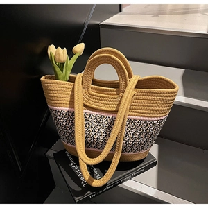 Detail of a large woven tote bag with round handles and floral tulip decor on books
