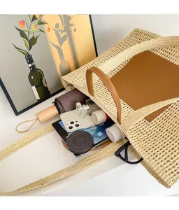 Spacious straw tote bag showing internal capacity for umbrella, phone and tablet