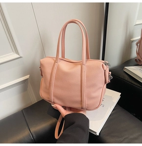 Detail of pink lychee leather handbag with dual handles and detachable shoulder strap