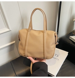 Detail of light brown lychee grain PU leather handbag with detachable shoulder strap