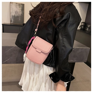Détail du petit sac bandoulière rose en cuir grainé avec un charm de lapin mignon