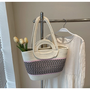 Detail of hand-woven tote bag with dual straps and stylish pink patterned accents