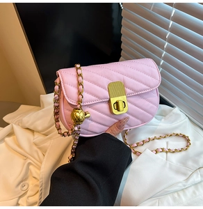 Détail du sac à bandoulière matelassé rose avec chaîne dorée et réglage ananas