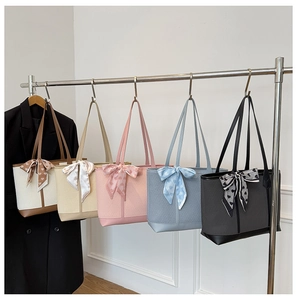 Détail de sacs fourre-tout tissés avec d'élégants foulards en soie à imprimé cœur