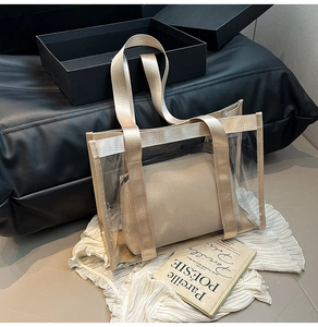 Détail d'un sac cabas en PVC transparent avec poignées tressées dorées et pochette