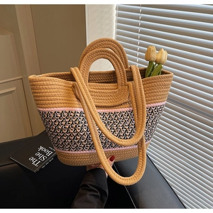 Detail of hand-woven tote bag showing geometric patterns and dual shoulder strap design