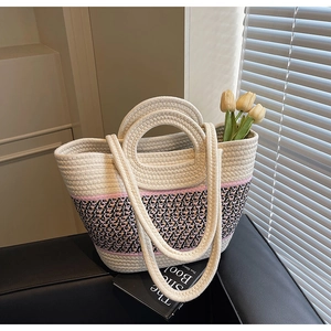 Close-up of handwoven tote bag featuring tri-color patterns and circular handles