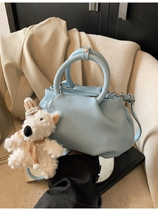 Light blue pleated bucket bag in lychee texture leather with a plush puppy charm