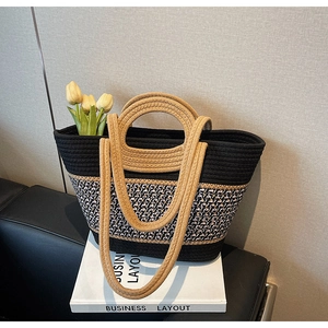 Detail of woven bucket bag featuring wooden handles, tricolor accents and cotton texture