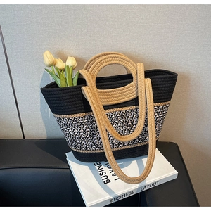 Close-up of woven tote bag with tricolor pattern and round handles on a sofa