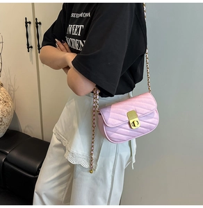 Détail du sac carré rose matelassé avec fermoir rotatif doré et bandoulière chaîne