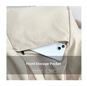 Front pocket detail of canvas backpack showing storage capacity with a smartphone