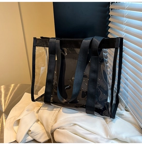 Détail d'un cabas transparent en PVC avec sangles noires sur une table en métal