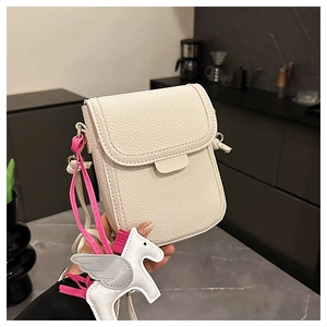 Détail du sac bandoulière en cuir grainé blanc cassé avec pendentif pégase blanc