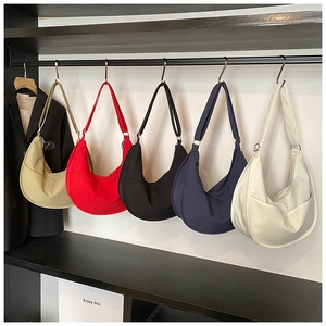 Detailed close-up of crescent-shaped nylon crossbody bags in five versatile colors