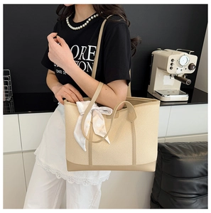 Détail d'un grand sac cabas beige avec texture tissée et foulard décoratif à pois