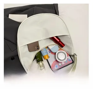 Spacious interior of the cream crescent bag showing storage for phone and cosmetics