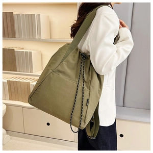 Detail shot of army green drawstring backpack with decorative cords and side woven label