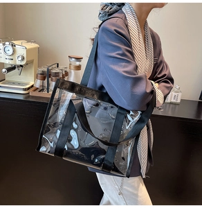 Détail du sac cabas transparent en PVC avec sangles noires dans un café chic