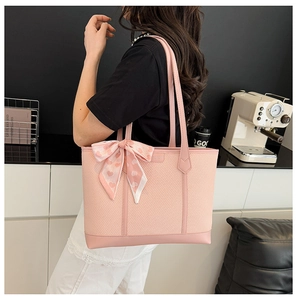 Détail du sac cabas rose tissé avec ruban en soie à cœurs et finitions en cuir