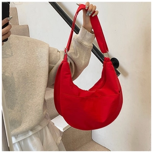 Detail of red crescent shoulder bag with adjustable strap and front pocket detail