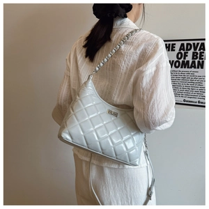 Détail du sac à main matelassé en cuir verni gris-bleu avec chaîne et fermoir pivotant