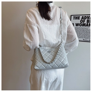 Détail du sac en cuir matelassé gris clair avec chaîne en métal argenté et fermoir