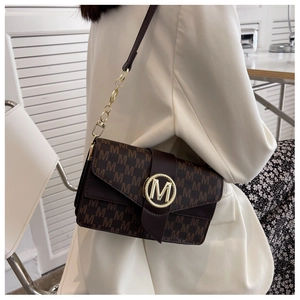 Détail du sac à main marron vintage avec boucle dorée M et bandoulière en chaîne