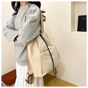 Detail view of large canvas bucket bag with drawstring and wide fabric shoulder strap