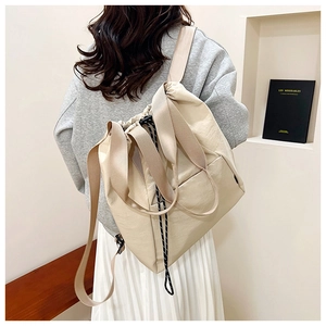 Rear view of a cream drawstring backpack on a model wearing casual grey sweatshirt and skirt