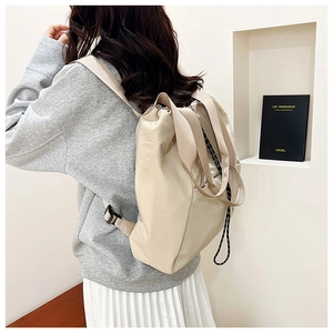 Close-up of stylish off-white nylon backpack featuring black and white drawstring details