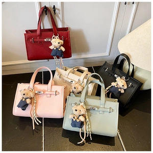 Detail of five-color leather tote bags with metal buckles and cute bear charms