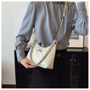 Vue détaillée du sac à main beige matelassé avec motif losange et chaîne en métal