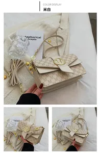 Détail du sac bandoulière blanc cassé avec monogramme M et logo en métal doré brillant