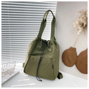Detail view of military green nylon bucket bag featuring a drawstring closure and wave pattern
