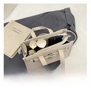 Detail view of cream-colored pebble leather handbag showing spacious interior for phone and cosmetics