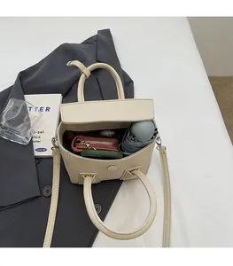 Internal view of beige litchi grain leather handbag showing capacity for daily items